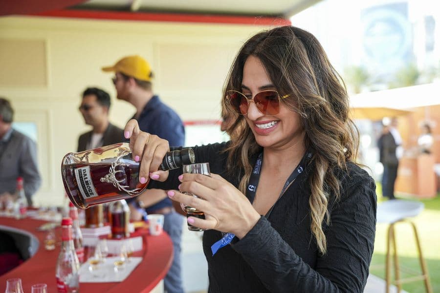 A guest smiling as she tastes at a pouring station