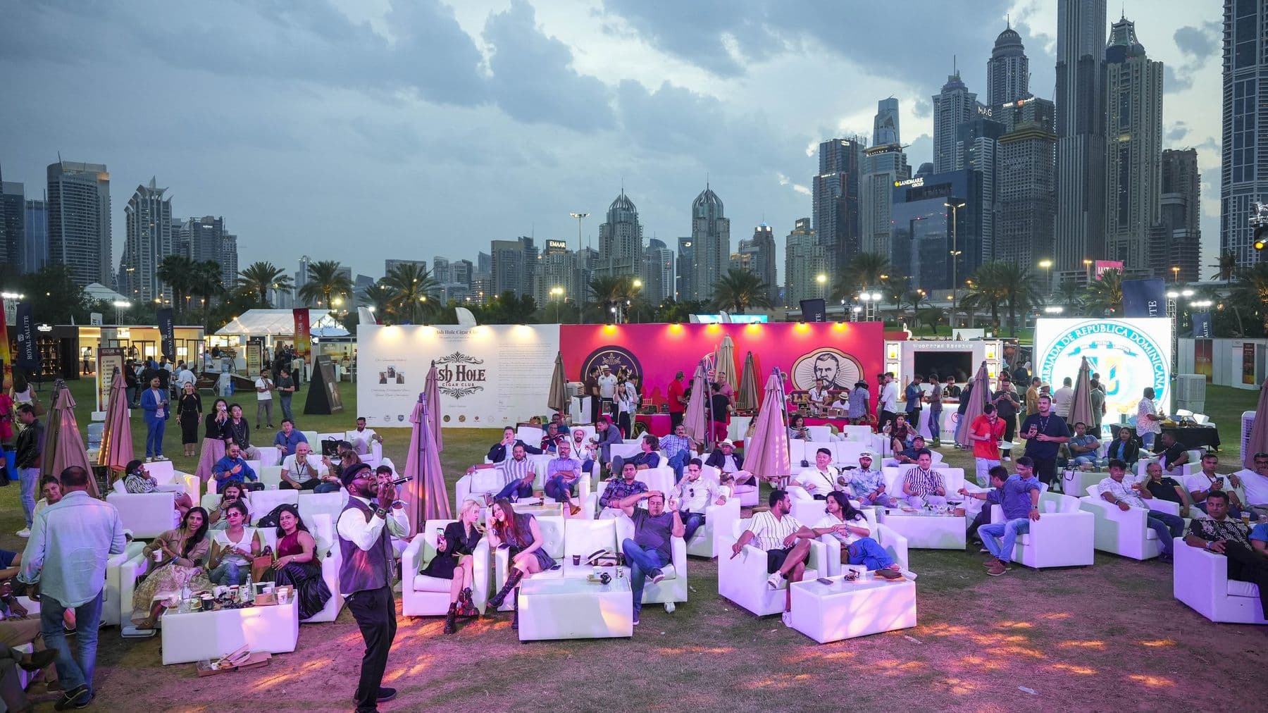 The MaltLive lawn at sunset, tables and umbrellas beneath the Marina towers