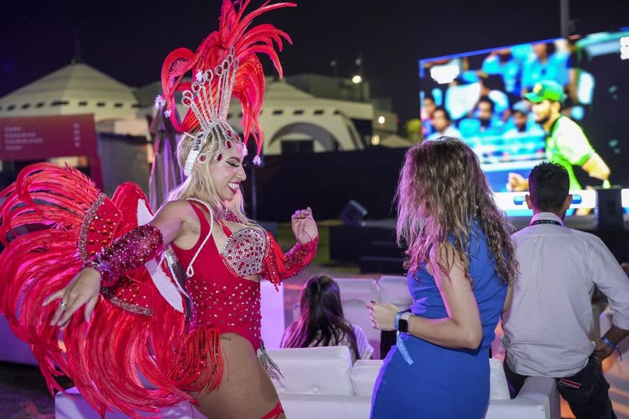 A samba dancer performing beside the stands after dark