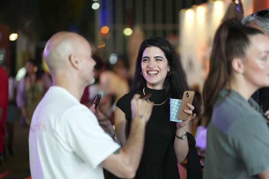 Guests laughing at a stand under night lighting