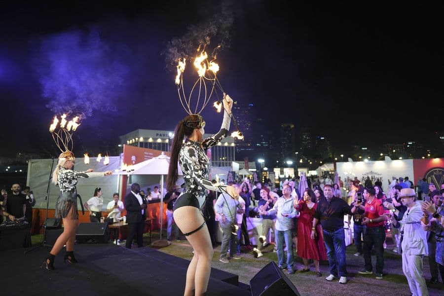 A fire performer on stage in front of the evening crowd