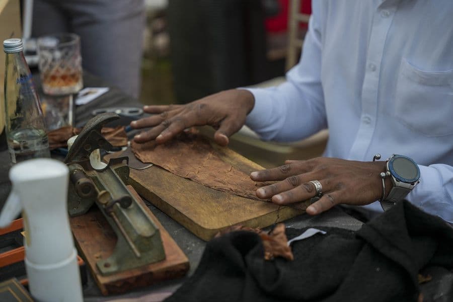 A cigar being prepared on a wooden board