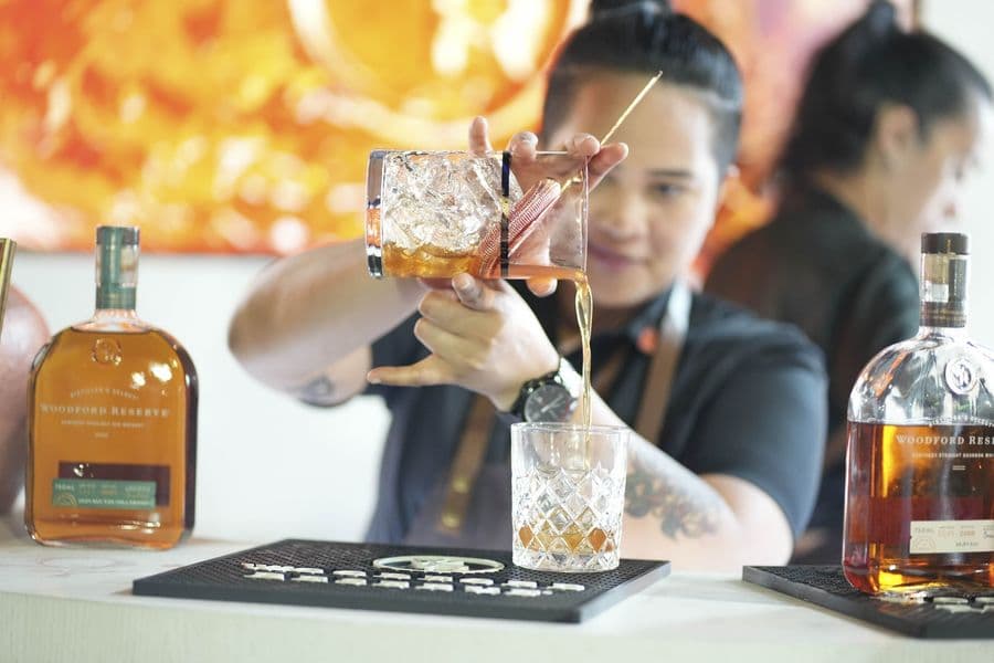 A cocktail being finished with a garnish