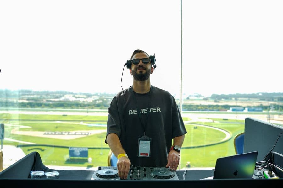 The DJ at the decks overlooking the track
