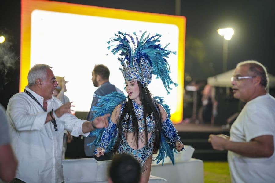 A carnival performer in feathered costume on the floor