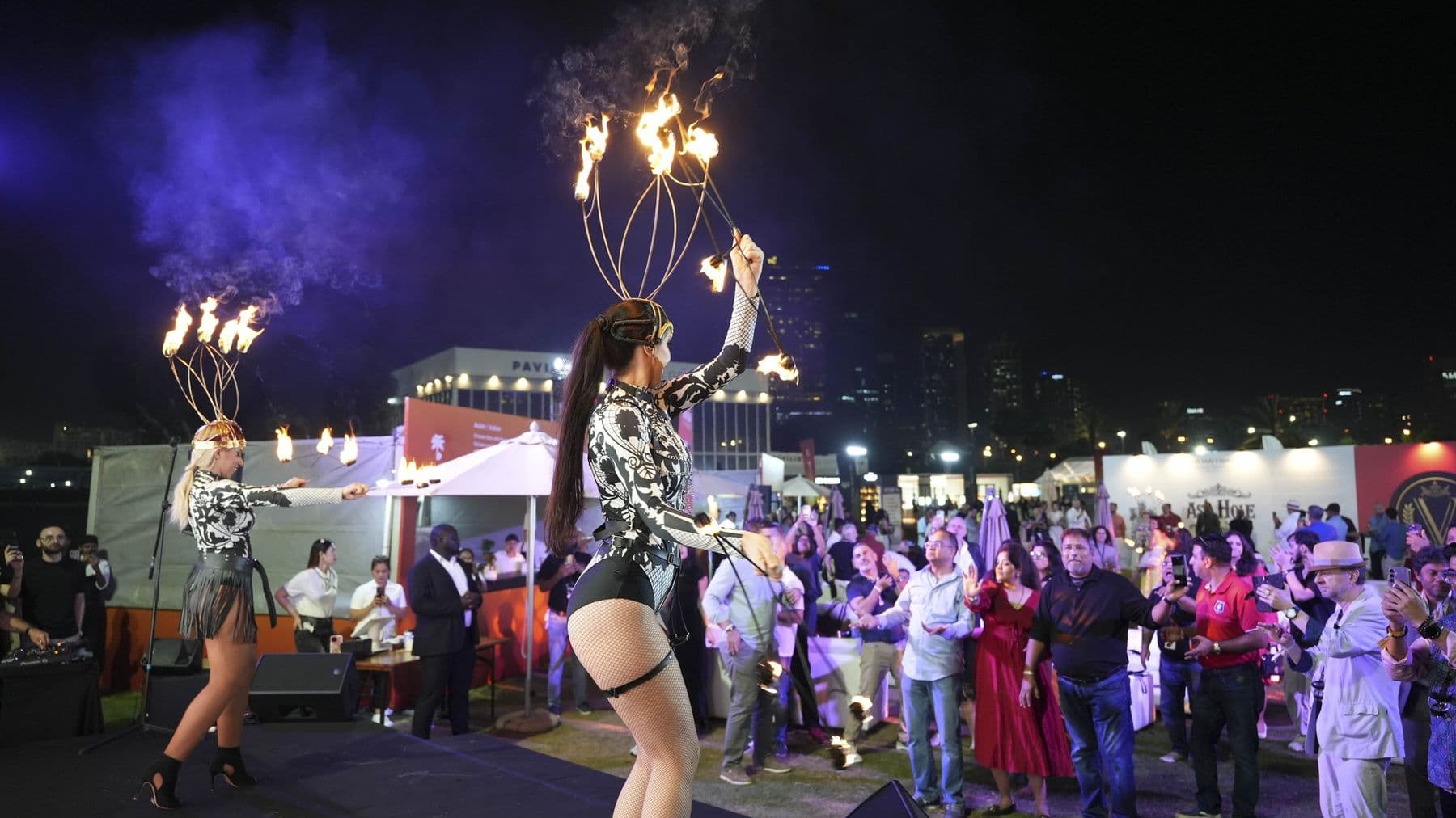 A fire performer on stage in front of the evening crowd