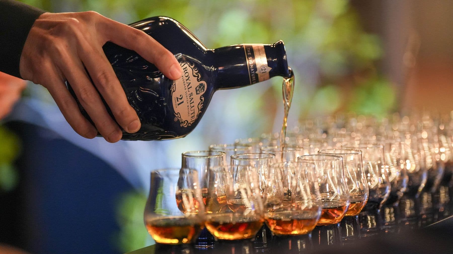 Whisky poured over a row of filled nosing glasses