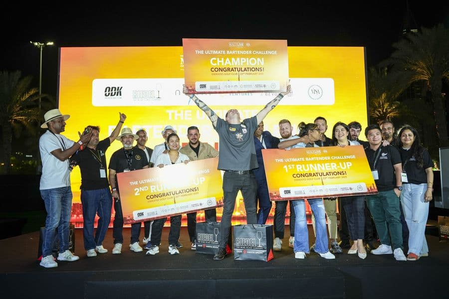 The winner holding the oversized cheque with the judging panel
